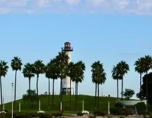A beautiful view of the Long Beach lighthouse surrounded by palm trees during the day. in Long Beach Scavenger Hunt