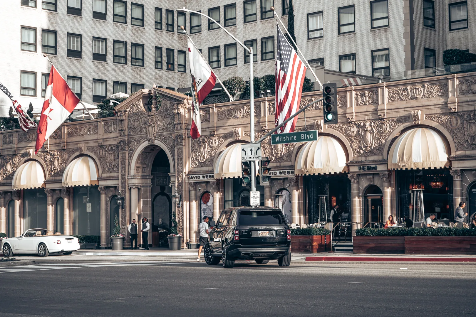 Elegant Beverly Hills street scene featuring a famous hotel with classic architecture and a Range Rover. in Beverly Hills Scavenger Hunt