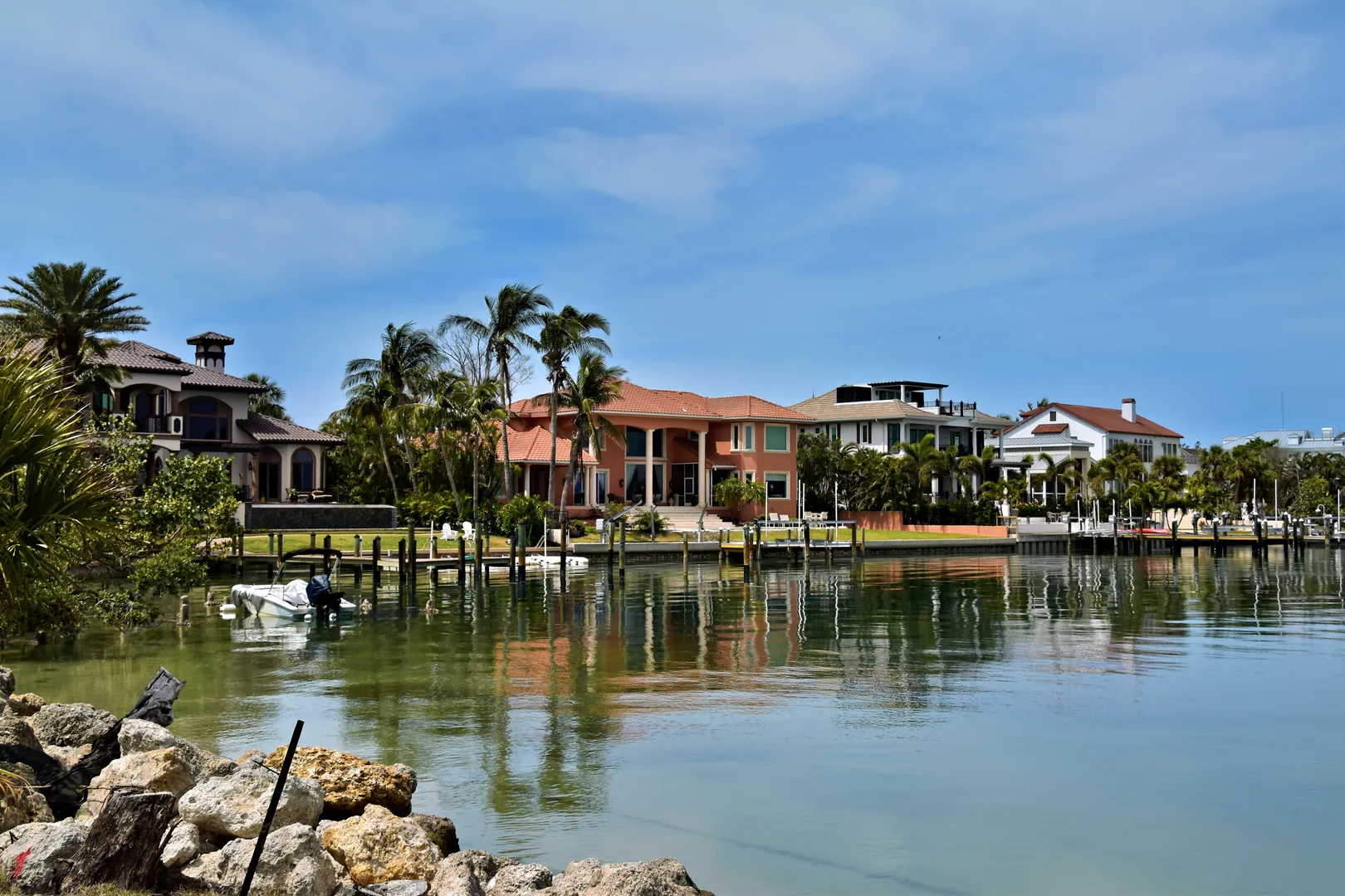 Scenic view of luxury homes along the Sarasota waterfront, surrounded by palm trees and calm waters. in Sarasota Scavenger Hunt