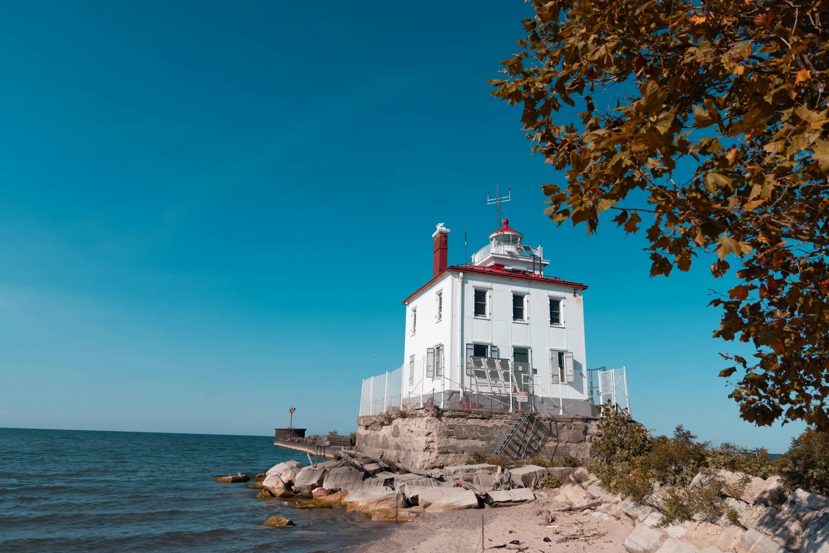 A historic lighthouse on Lake Erie's coast captures the essence of autumn under a clear blue sky. in Erie Scavenger Hunt
