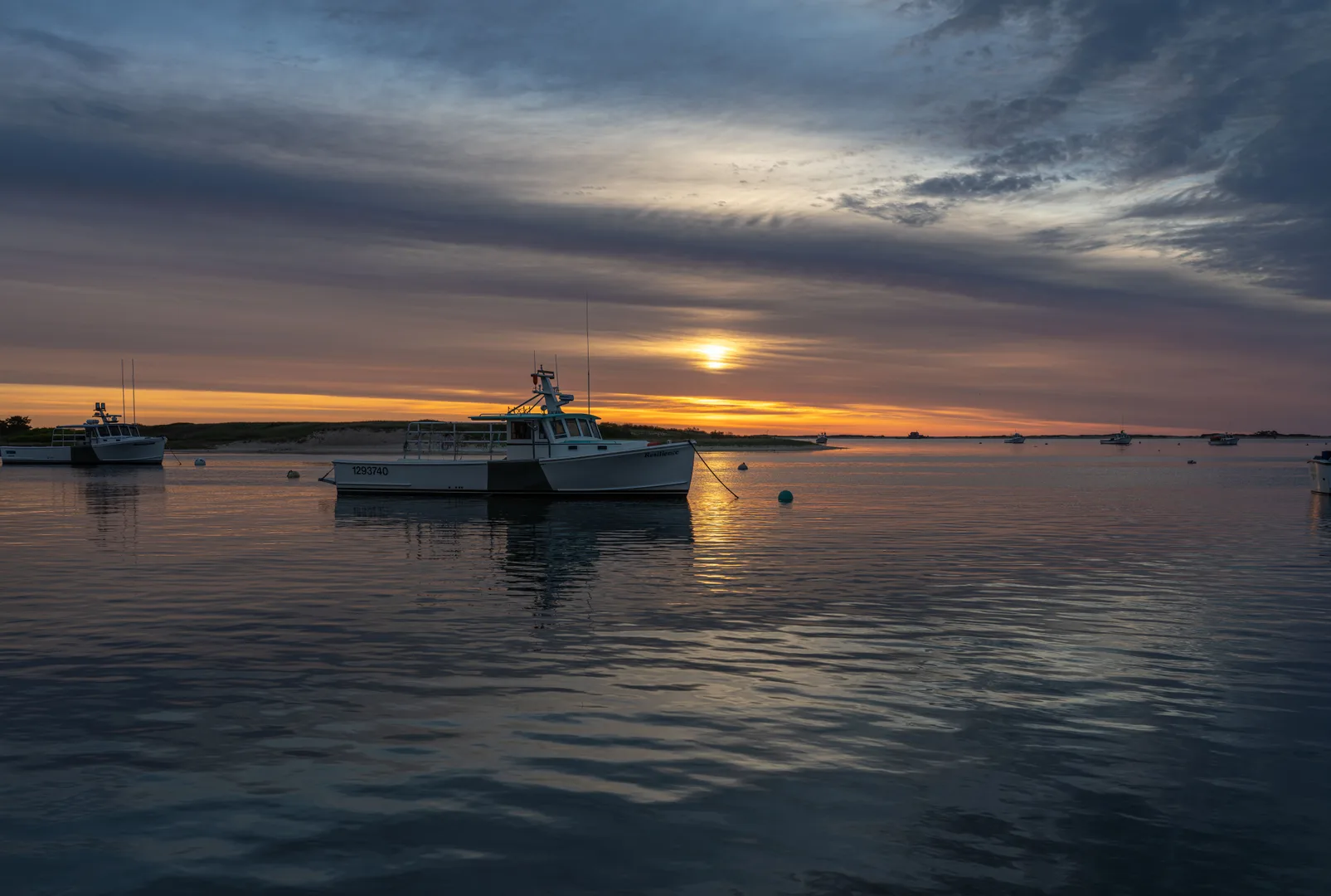 Peaceful sunrise with boats in Chatham Harbor, Massachusetts, creating a serene and scenic view. in Chatham Massachusetts Scavenger Hunt